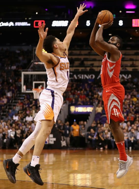 James Harden of the Houston Rockets attempts a shot over Devin Booker of the Phoenix Suns during the first half, at Talking Stick Resort Arena in Phoenix, Arizona, on November 16, 2017