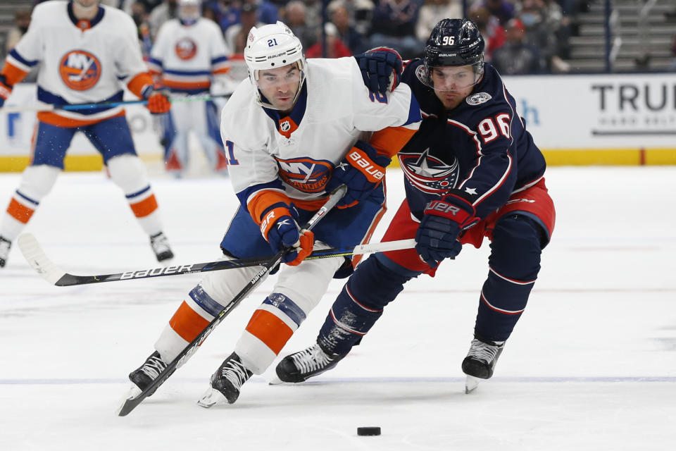 Columbus Blue Jackets' Jack Roslovic, right, tries to steal the puck from New York Islanders' Kyle Palmieri during the first period of an NHL hockey game Thursday, Oct. 21, 2021, in Columbus, Ohio. (AP Photo/Jay LaPrete)