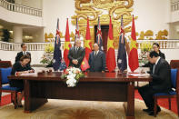 Australian Prime Minister Scott Morrison, center left, and his Vietnamese counterpart Nguyen Xuan Phuc, center right, witness a signing ceremony at the Government Office in Hanoi, Friday, Aug. 23, 2019. Morrison is on an official visit to Vietnam from Aug. 22-24, 2019. (AP Photo/Duc Thanh, Pool)