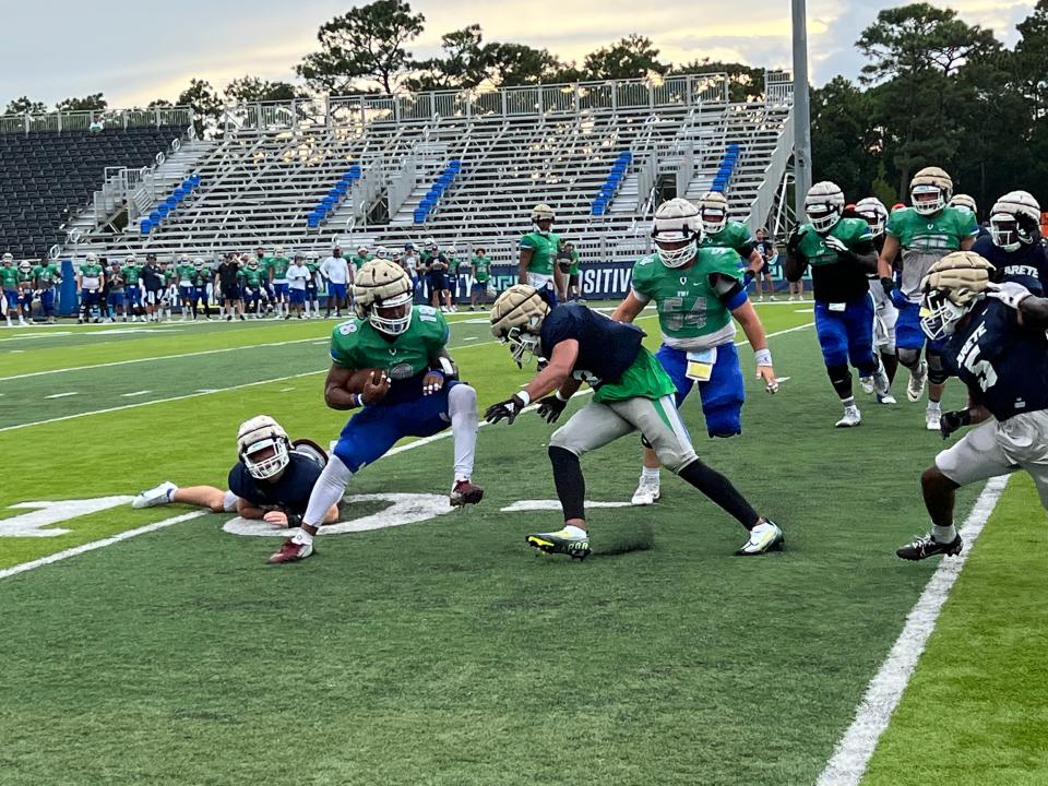 Running back Deonte Sheffield (18), a Niceville High grad and transfer from Florida State, looks for running room during Friday's night's UWF scrimmage at Pen-Air Field.