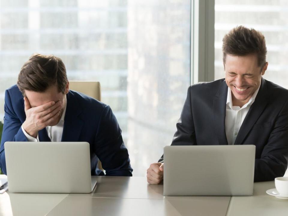 Two businessmen laughing out loud, good positive emotions at workplace