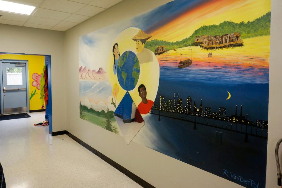 A mural on the wall shows people from around the world at A Million Dreamz child care center in Sheboygan, Wis.
