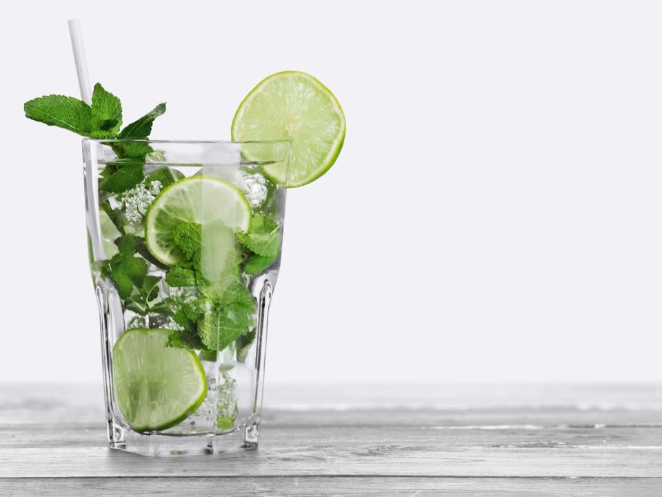 A vodka drink with lime and mint leaves.