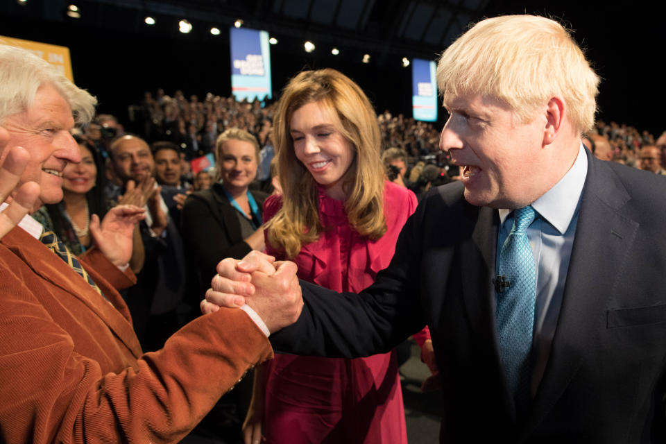 Prime Minister Boris Johnson leaves the stage with his partner Carrie Symonds as he is congratulated by his father Stanley Johnson after delivering his speech during the Conservative Party Conference at the Manchester Convention Centre.