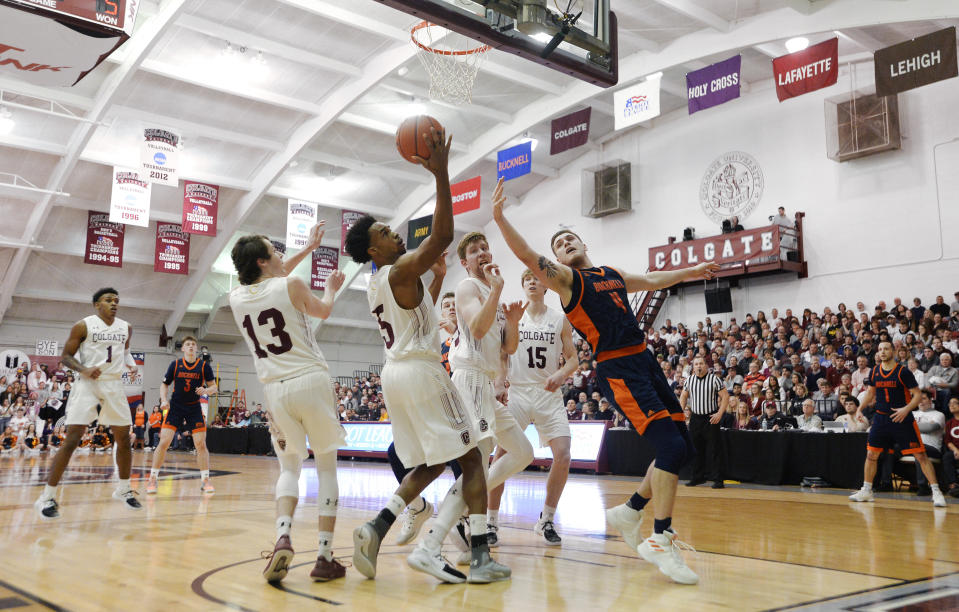 Colgate forward Malcolm Regisford (5) reaches for a rebound next to Bucknell center Nate Sestina (4) during the first half of an NCAA college basketball game for the championship of the Patriot League men's tournament in Hamilton, N.Y., Wednesday, March 13, 2019. (AP Photo/Adrian Kraus)