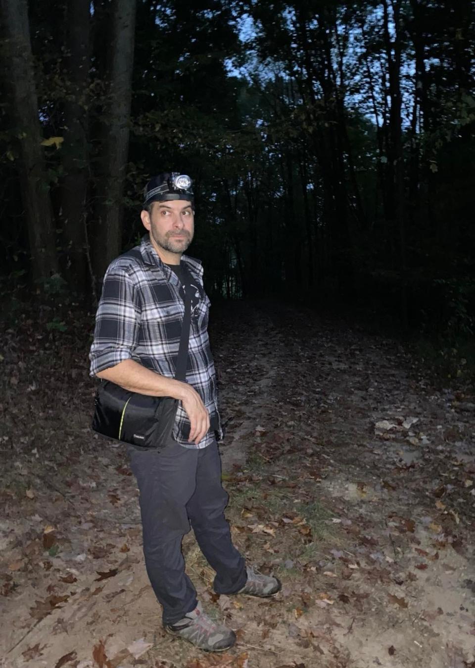 Filmmaker Seth Breedlove of the Wadsworth-based Small Town Monsters stands along a path in the Minerva area wilderness last month.  The Bolivar native's latest YouTube series, "The Bigfoot Project," explores what he believes may be an undiscovered creature that has been roaming remote woodlands.