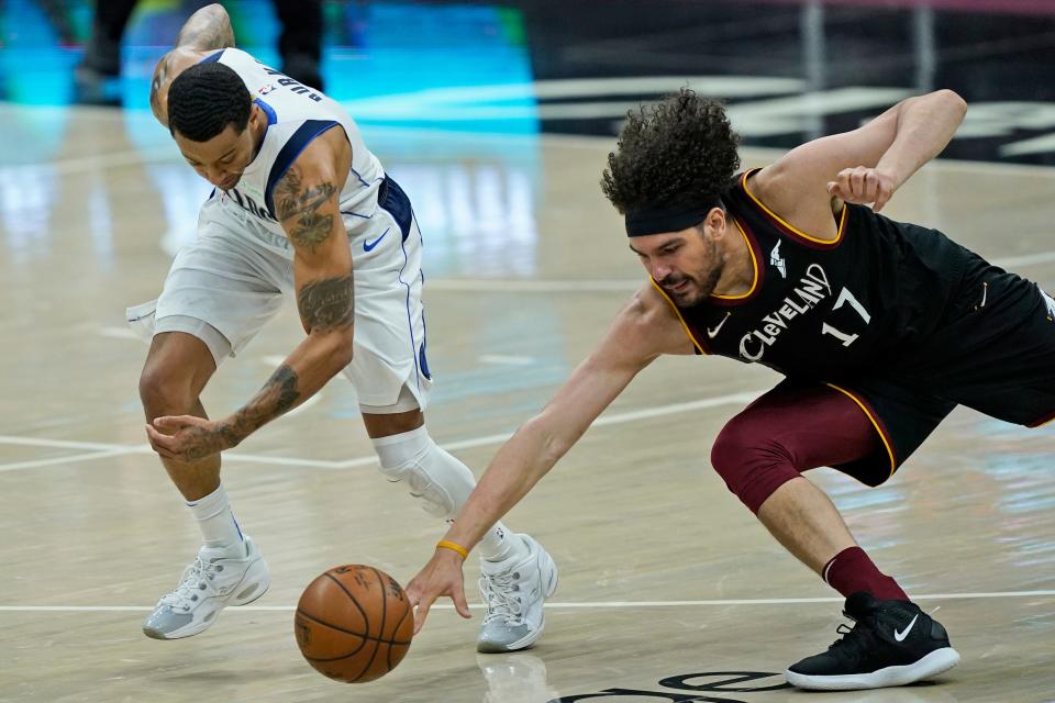 Dallas Mavericks guard Trey Burke and Cavaliers forward Anderson Varejao battle for a loose ball in the second half, Sunday, May 9, 2021, in Cleveland.