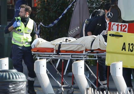 A victim is removed from the scene where shots were fired during a police search of a house in the suburb of Forest near Brussels, Belgium, March 15, 2016. REUTERS/Francois Lenoir