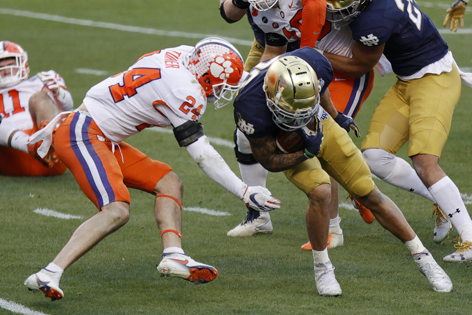 CHARLOTTE, NORTH CAROLINA - DECEMBER 19: Running back Kyren Williams #23 of the Notre Dame Fighting Irish is tackled by safety Nolan Turner #24 of the Clemson Tigers in the first half during the ACC Championship game at Bank of America Stadium on December 19, 2020 in Charlotte, North Carolina. (Photo by Jared C. Tilton/Getty Images)