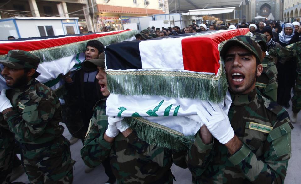 Members of Shi'ite group Asaib Ahl al-Haq, who support Syrian President Bashar al-Assad, carry the coffins of fighters from their group, during a funeral in Najaf