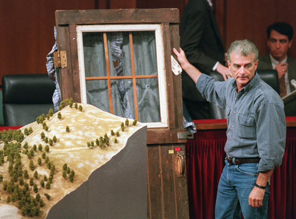 FILE - In this Sept. 6, 1995, file photo, Randy Weaver holds the door of his cabin showing holes from bullets fired during the 1992 siege of his Ruby Ridge, Idaho, home, model at left, during testimony before the Senate Judiciary Subcommittee on Capitol Hill in Washington. The standoff in the remote mountains of northern Idaho left a 14-year-old boy, his mother and a federal agent dead and sparked the expansion of radical right-wing groups across the country. (AP Photo/Joe Marquette, File)