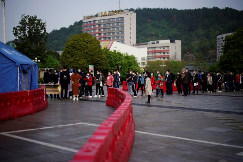 People wearing face masks line up outside Xianning Central Hospital in Xianning