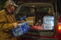 John Beezley, of Bonham, loads several cases of water after learning that a boil water notice was issued for the entire city of Houston on Sunday, Nov. 27, 2022, at Walmart on S. Post Oak Road in Houston. Beezley just arrived in town with his wife, who is undergoing treatment starting tomorrow at M.D. Anderson Cancer Center, where they are staying in a camping trailer. They turned on the television after settling in and saw that a boil water notice had been issued. Beezley decided to go out immediately fearing that by tomorrow people would be buying up all of the available water. (Mark Mulligan/Houston Chronicle via AP)