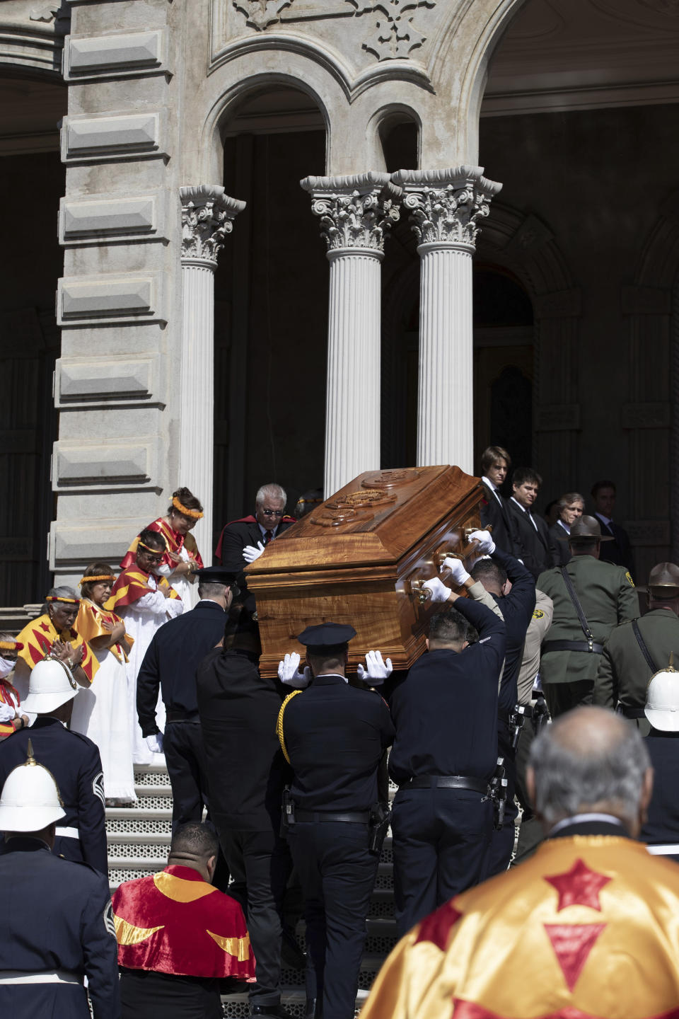 Law enforcement honor guards carry Abigail Kinoiki Kekaulike Kawananakoa's wooden casket up the palace stairs to the throne room during a public memorial at 'Iolani Palace, Sunday, Jan. 22, 2023, in Honolulu. The Campbell estate heiress with royal lineage died on Dec. 11, 2022, at the age of 96. (Cindy Ellen Russell/Honolulu Star-Advertiser via AP)