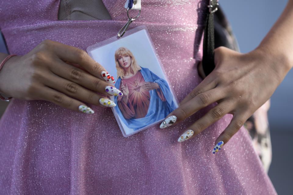 Una fan con una imagen de Taylor Swift con motivos religiosos antes del primer concierto de la gira Eras de Swift en el estadio Monumental en Buenos Aires, Argentina, el jueve 9 de noviembre de 2023. (Foto AP/Natacha Pisarenko)