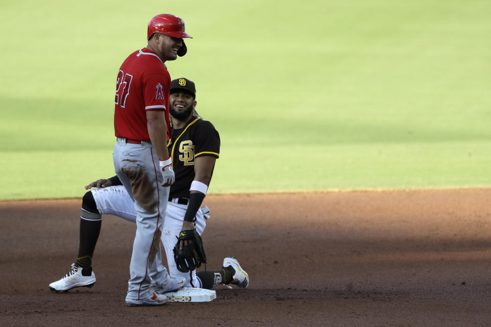 San Diego Padres shortstop Fernando Tatis Jr., right, jokes with Los Angeles Angels' Mike Trout after Trout arrived safely at second base off a throwing error by starting pitcher Garrett Richards during the first inning of an exhibition baseball game at Petco Park, Monday, July 20, 2020, in San Diego. (AP Photo/Gregory Bull)