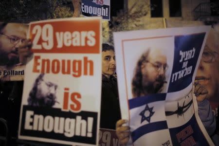 Israelis hold placards depicting Jonathan Pollard during a protest calling for his release from a U.S. prison, outside U.S. Secretary of State John Kerry's hotel in Jerusalem January 2, 2014. REUTERS/Ammar Awad