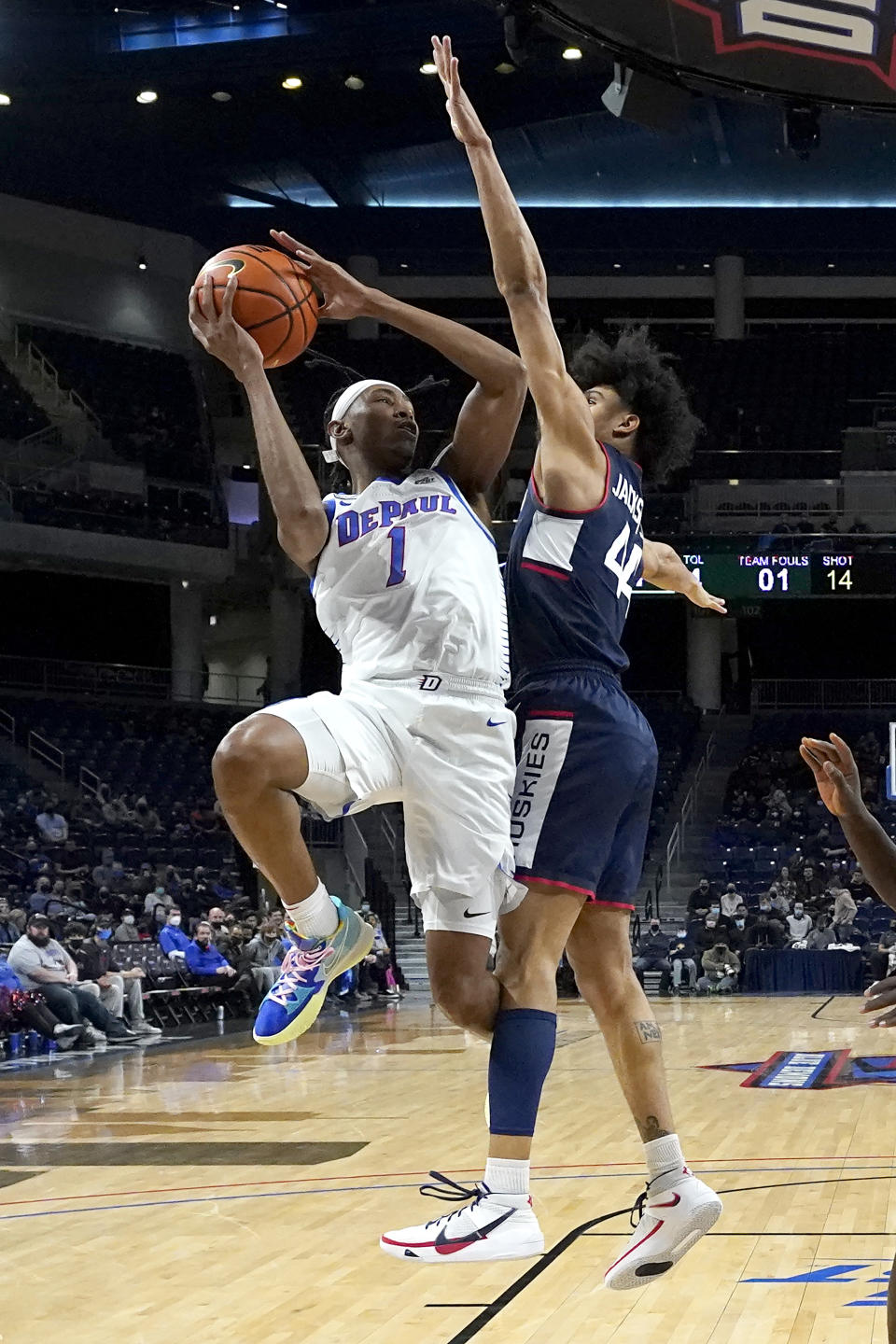 DePaul's Javan Johnson (1) shoots under pressure from Connecticut's Andre Jackson during the first half of an NCAA college basketball game Saturday, Jan. 29, 2022, in Chicago. (AP Photo/Charles Rex Arbogast)