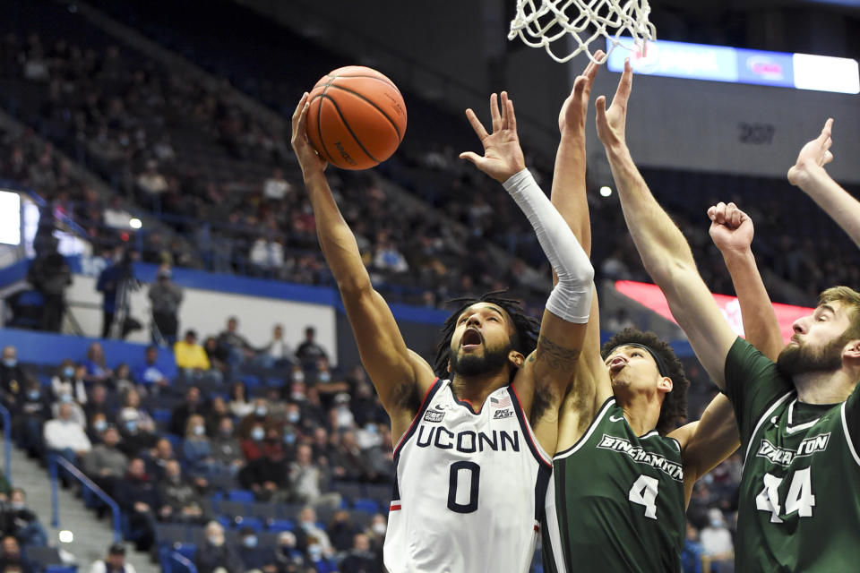 Connecticut's Jalen Gaffney (0) goes up for two against Binghamton's Kellen Amos (4) and Yarden Willis (44) during the first half of an NCAA college basketball game Saturday, Nov. 20, 2021, in Hartford, Conn. (AP Photo/Stephen Dunn)