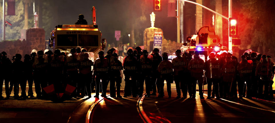 Several area law enforcement agencies stand at the intersection of University Boulevard and Park Avenue after ejecting a small group of pro-Palestinian demonstrators off the University of Arizona campus, Friday, May 10, 2024, Tucson, Az. (Kelly Presnell/Arizona Daily Star via AP)