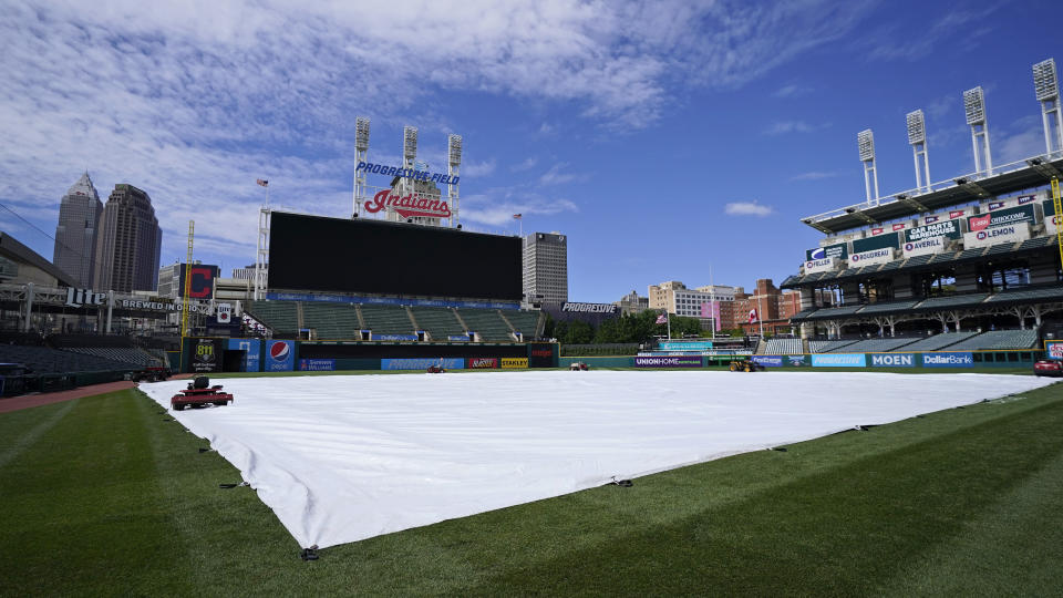 The tarp rests on the field after a baseball game between the Toronto Blue Jays and the Cleveland Indians was postponed due to inclement weather, Saturday, May 29, 2021, in Cleveland. The game will be rescheduled as a traditional doubleheader Sunday. (AP Photo/Tony Dejak)