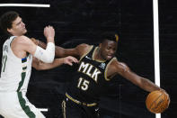 Atlanta Hawks center Clint Capela (15) reaches for the ball next to Milwaukee Bucks center Brook Lopez (11) during the second half of an NBA basketball game Thursday, April 15, 2021, in Atlanta. (AP Photo/John Bazemore)