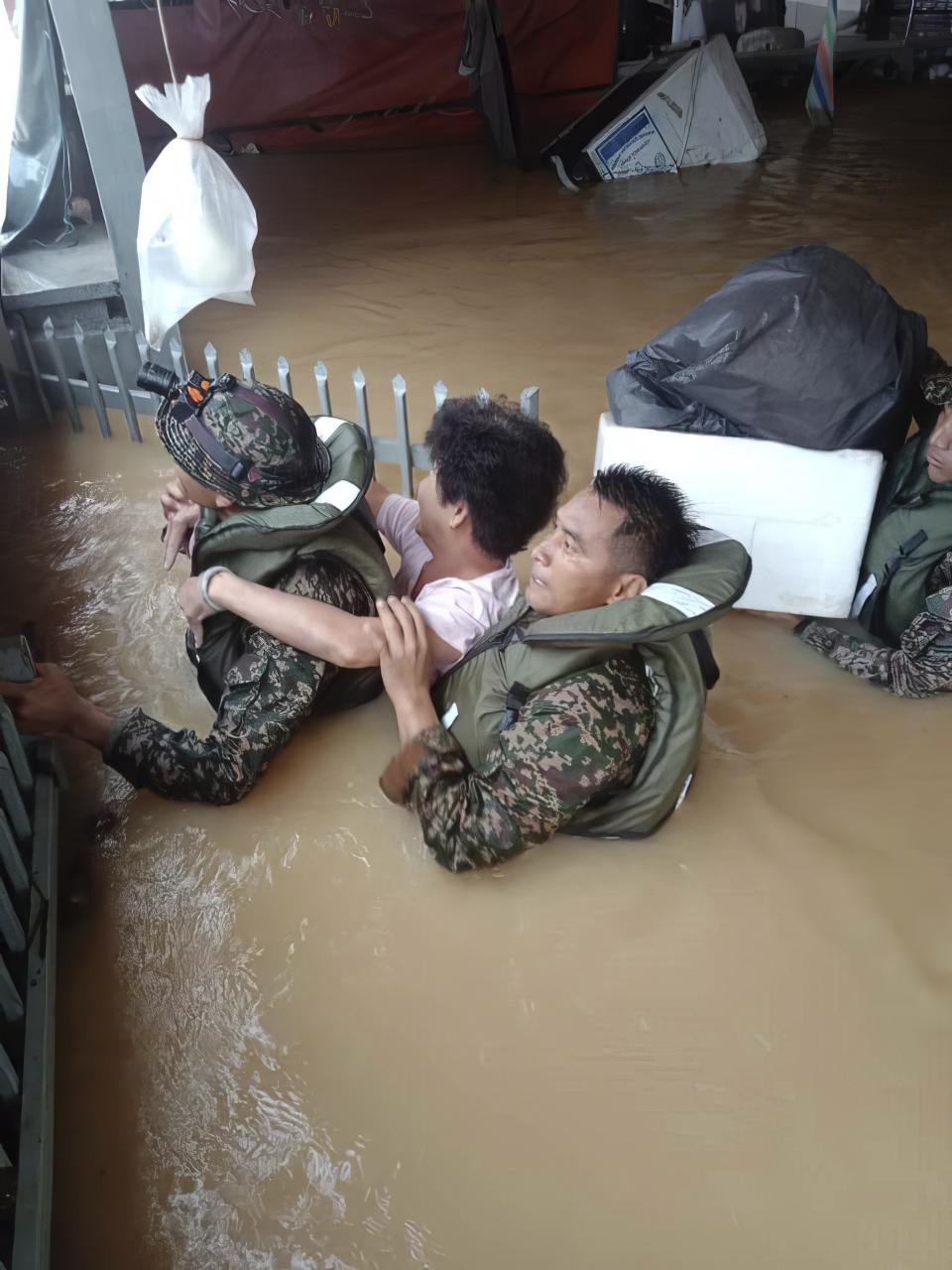 In this photo released by National Disaster Management Agency, the army evacuate residents on Chaah town in Segamat, in southern Johor state, Malaysia, Wednesday, March 1, 2023. Rescuers in boats plucked flood victims trapped on rooftops and hauled others to safety as incessant rain submerged homes and villages in parts of Malaysia, leading to over 26,000 people evacuated as of Thursday. (National Disaster Management Agency via AP)