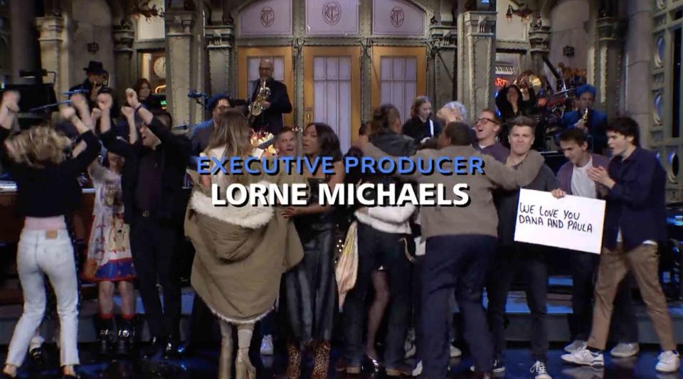 Colin Jost holds sign for Dana Carvey during 