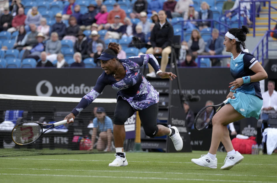 Serena Williams of the United States, left, returns the ball as Ons Jabeur of Tunisia looks on during their doubles tennis match against Marie Bouzkova of Czech Republic and Sara Sorribes Tormo of Spain at the Eastbourne International tennis tournament in Eastbourne, England, Tuesday, June 21, 2022. (AP Photo/Kirsty Wigglesworth)