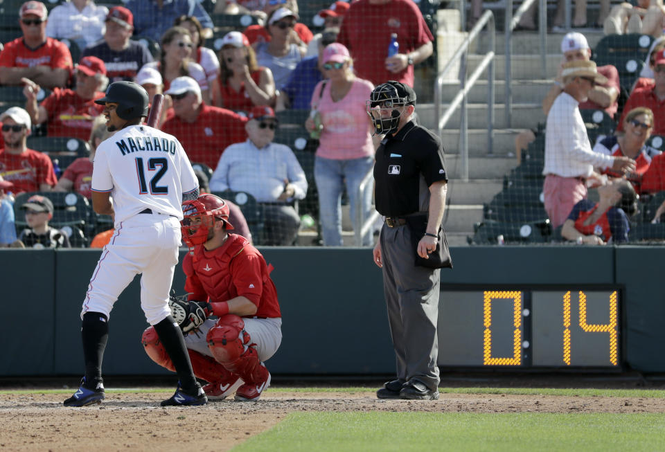 Miami Marlins' Dixon Machado (12) bats as a pitch clock counts down in the background during the sixth inning of an exhibition spring training baseball game against the St. Louis Cardinals Saturday, Feb. 23, 2019, in Jupiter, Fla. The league is experimenting with a pitch clock through spring training, putting hurlers and hitters on the clock for the first time in an effort to shorten games. (AP Photo/Jeff Roberson)