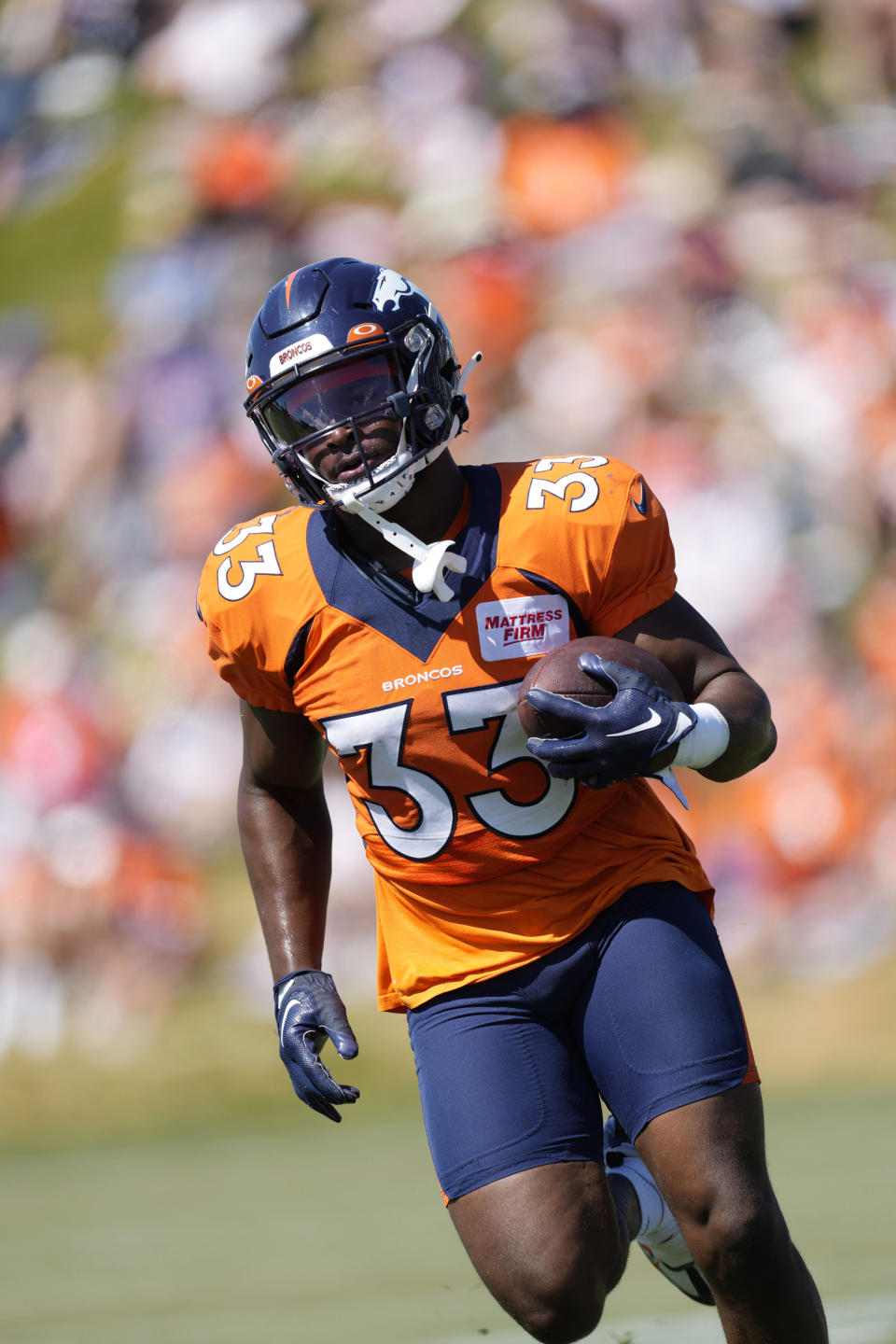 FILE - Denver Broncos running back Javonte Williams takes part in drills during an NFL football training camp session at the team's headquarters Monday, Aug. 8, 2022, in Centennial, Colo. Broncos running back Javonte Williams is using his downtime as he recovers from an injured right knee to feed his other passion: helping foster kids.(AP Photo/David Zalubowski, File)