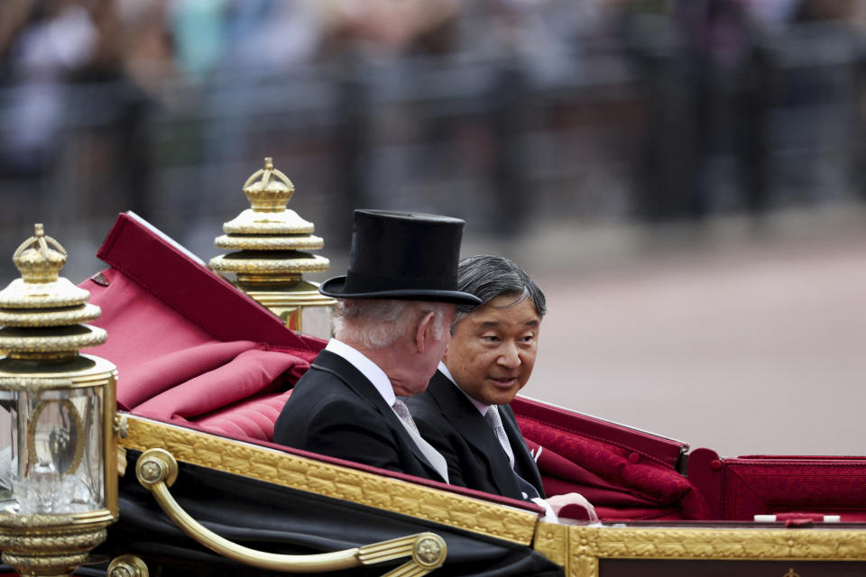 Japan's Emperor Naruhito, accompanied by Britain's King Charles, rides in a carriage on the day of a state visit, in London, Britain, Tuesday, June 25, 2024. (Isabel Infantes/Pool photo via AP)