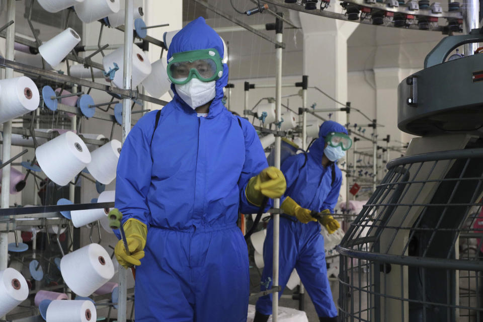 Employees of Songyo Knitwear Factory in Songyo district disinfect the work floor in Pyongyang, North Korea, Wednesday, May 18, 2022, after Kim Jong Un said Tuesday his party would treat the country's outbreak under the state emergency. North Korea said Wednesday more than a million people have already recovered from suspected COVID-19 just a week after disclosing an outbreak it appears to be trying to manage in isolation as global experts express deep concern about the public health threat. (AP Photo/Jon Chol Jin)