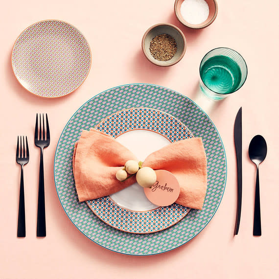 Pictured: Hermès Tie-Set American dinner plate, $150; dessert plate, $115; and bread-and-butter plate, $85, hermes.com. Cutipol Duna flatware collection, in Matte Black, $92 for a 5-piece set, abchome.com. Hawkins New York Simple linen napkin, in Blush, $18, hawkinsnewyork.com. Sulyn Clubhouse Crafts elastic cord, $4 for 6 colors, joann.com. American Woodcrafters Supply Co. unfinished round wooden beads, 5/8