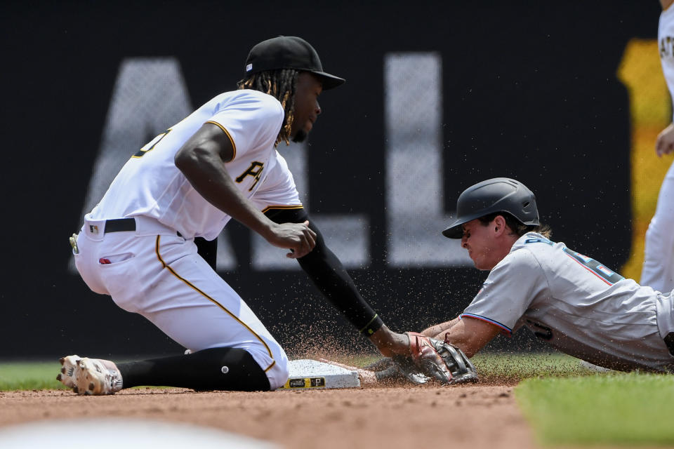 Miami Marlins' J,J. Bleday, right, slides safely into second with a stolen base as Pittsburgh Pirates shortstop Oneil Cruz, left, applies the tag in the second inning of a baseball game, Sunday, July 24, in Pittsburgh. (AP Photo/Barry Reeger)