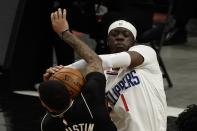 LA Clippers' Reggie Jackson ties up Milwaukee Bucks' D.J. Augustin during the first half of an NBA basketball game Sunday, Feb. 28, 2021, in Milwaukee. (AP Photo/Morry Gash)