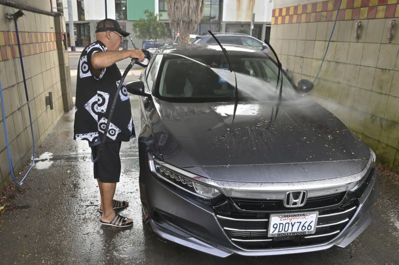 A man washes his car in Los Angeles on Monday. California Department of Transportation crews early Monday had a larger clean-up job removing mud and debris that had flowed onto highways throughout the region. Photo by Jim Ruymen/UPI