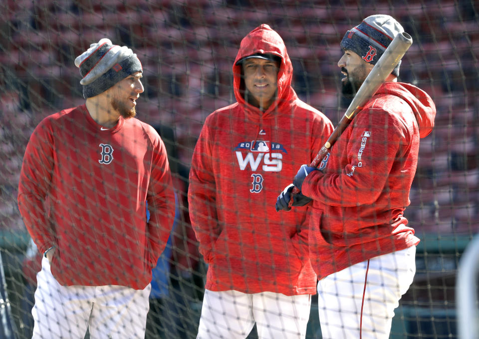 El manager de los Medias Rojas de Boston Alex Cora, en el medio, charla con los receptores Christian Vázquez (izquierda) y Sandy León (derecha) durante un entrenamiento en Fenway Park, el domingo 21 de octubre de 2018 en Boston. Los Medias Rojas enfrentan a los Dodgers en la Serie Mundial. (AP Foto/Elise Amendola)