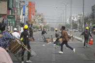 Protesters rush to try to block the road as police arrive during a protest against the military coup in Mandalay, Myanmar, Sunday, Feb. 28, 2021. Police in Myanmar escalated their crackdown on demonstrators against this month's military takeover, deploying early and in force on Saturday as protesters sought to assemble in the country's two biggest cities and elsewhere. (AP Photo)