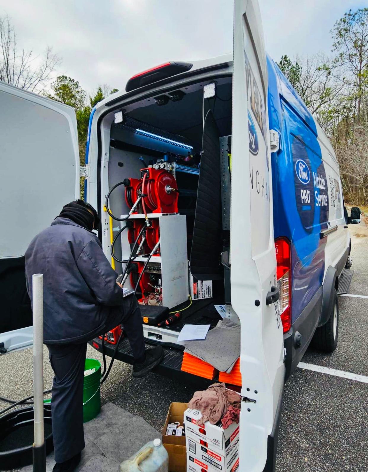 Andrea Wright, an employees of Stivers Ford, is seen here doing an oil change and tire rotation as part of mobile service in Montgomery, Alabama on March 27, 2024.