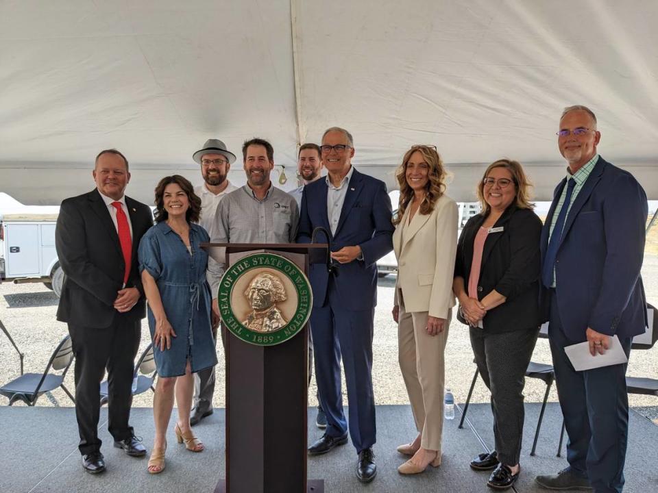 City officials and Tri-City lawmakers pose for a photo Friday, May 19, with Gov. Jay Inslee at the future expansion site of the Pasco process water reuse facility.