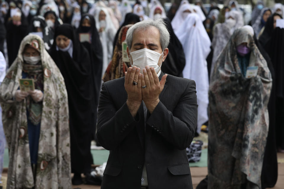 Fieles con mascarillas de protección durante las plegarias del Eid al-Fitr, rezando fuera de una mezquita para combatir el contagio del nuevo coronavirus, en Teherán, Irán, el domingo 24 de mayo de 2020. (AP Foto/Vahid Salemi)