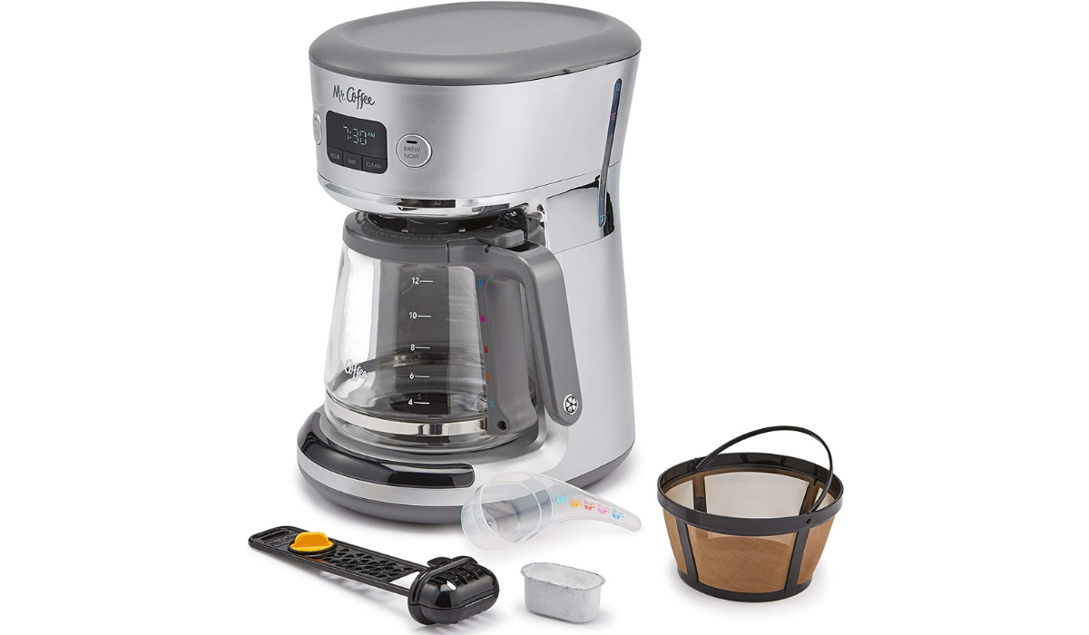 A silver coffee maker with accessories around it.