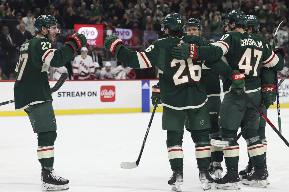 Minnesota Wild center Connor Dewar (26) celebrates with teammates after scoring a goal against the Carolina Hurricanes during the first period of an NHL hockey game Tuesday, Feb. 27, 2024, in St. Paul, Minn. (AP Photo/Stacy Bengs)