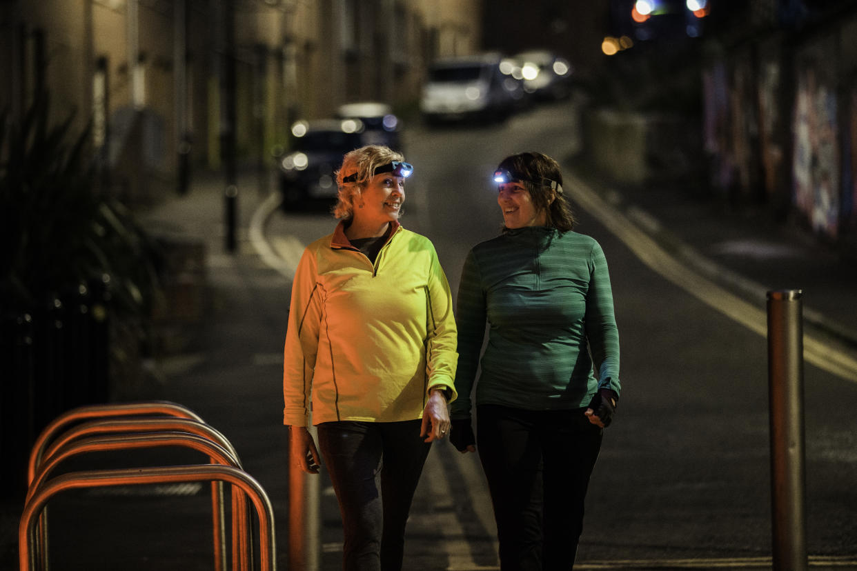 Two friends walking together in an urban environment at night