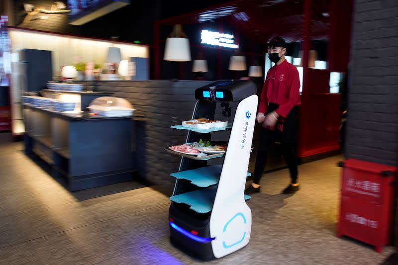 Un robot transporta comida para servirla a los comensales de un restaurante en Shanghai, China