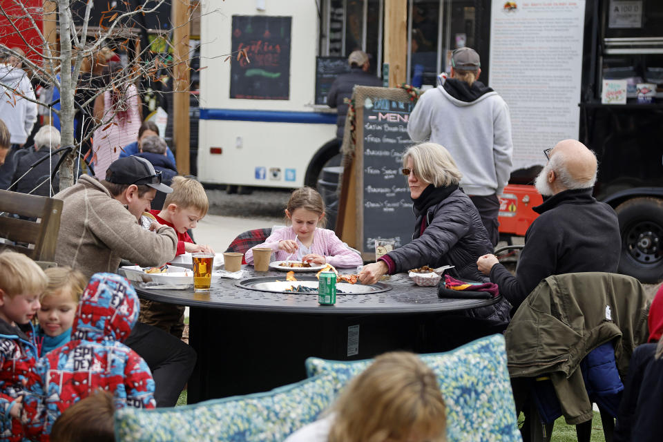 Residents of Southern Pines, N.C., have lunch while the power is out in the area at Reds Food Truck Corner in Southern Pines, N.C., Monday, Dec. 5, 2022. Tens of thousands of people braced for days without electricity in a North Carolina county where authorities say two power substations were shot up by one or more people with apparent criminal intent. (AP Photo/Karl B DeBlaker)