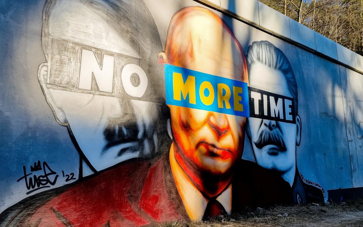 A mural of Putin, Hitler, and Stalin with a slogan " No More Time" is seen on the wall next to the PKM Gdansk Jasien train station