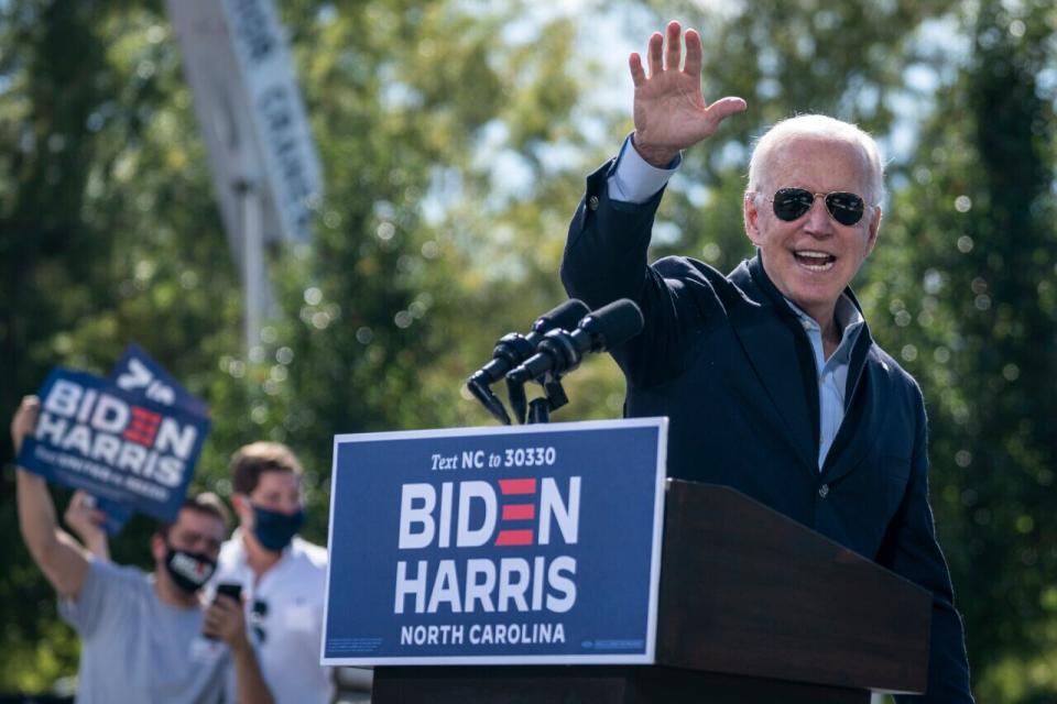 Democratic presidential nominee Joe Biden waves as he departs the stage during a drive-in campaign rally at Riverside High School on October 18, 2020 in Durham, North Carolina. (Photo by Drew Angerer/Getty Images)