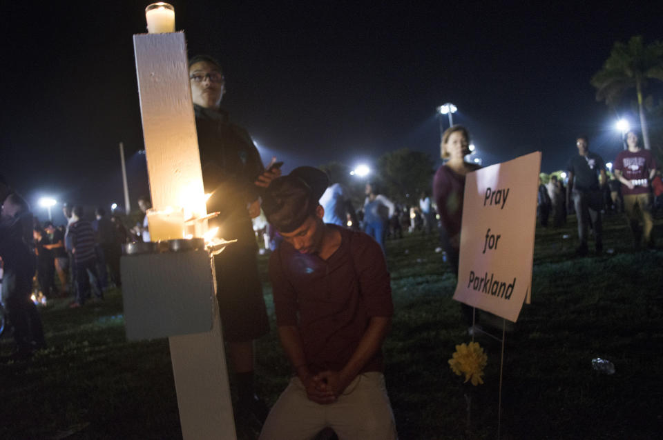 Jay Eaton, 19, prays at a vigil Thursday night, one day after a school shooting left 17 people dead.